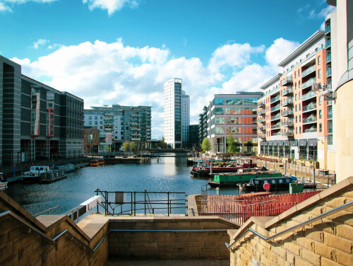 The docks at Leeds on a sunny day with steps leading down to the barges.
